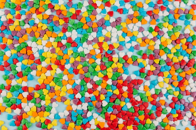 Muitos doces da forma do coração espalharam na superfície