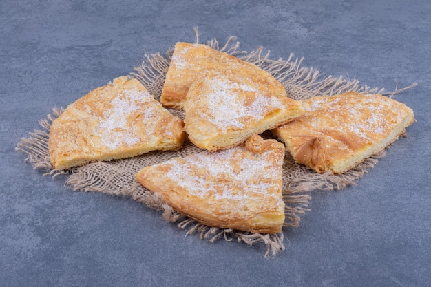 Muitos pedaços de torta deliciosa com açúcar em pó em um saco