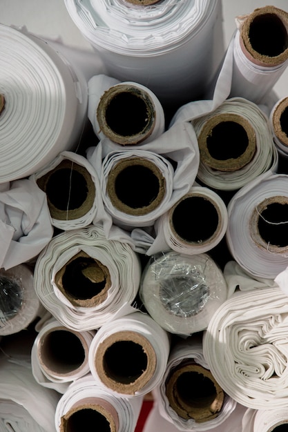 Foto grátis muitos rolos de tecido branco em um estúdio de alfaiate