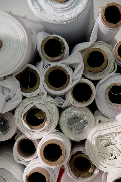 Muitos rolos de tecido branco em um estúdio de alfaiate