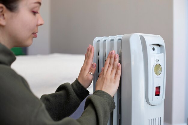 Mulher a aquecer perto do aquecedor