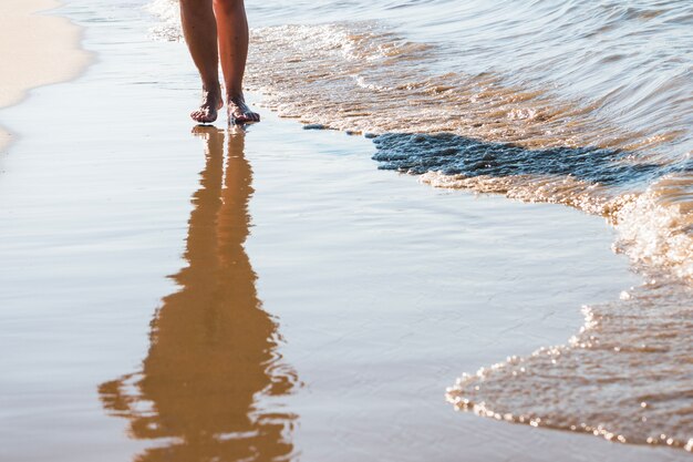 Mulher a caminhar na praia