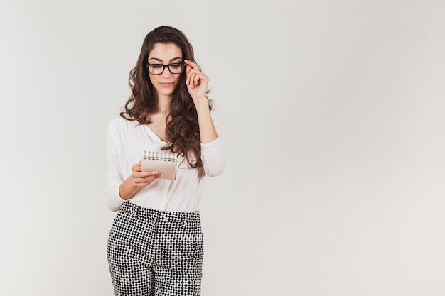 Foto grátis mulher à moda com os vidros que prendem um caderno