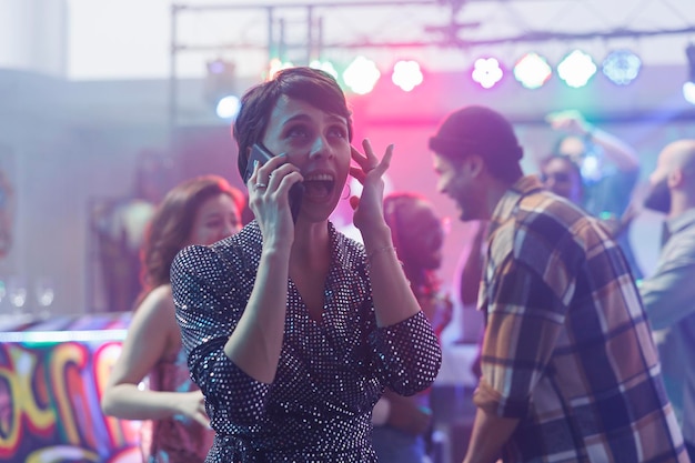 Foto grátis mulher a tentar falar ao telefone no clube.