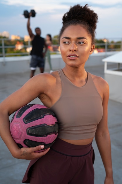 Foto grátis mulher a treinar ao ar livre com uma bola