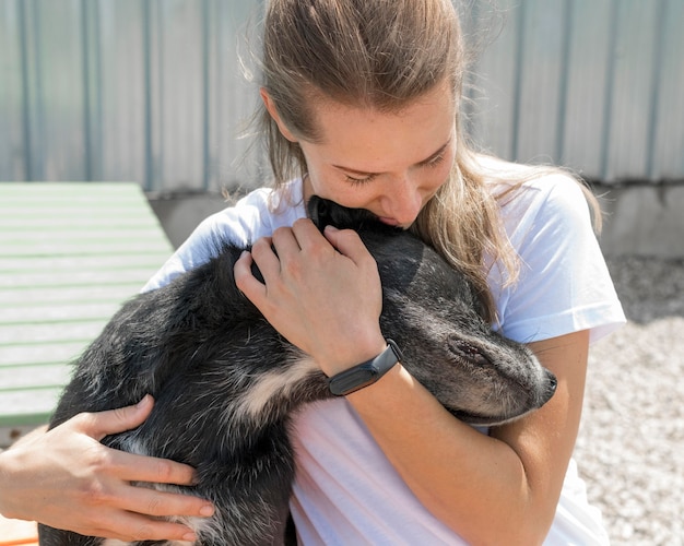 Mulher abraçando cachorro fofo de resgate