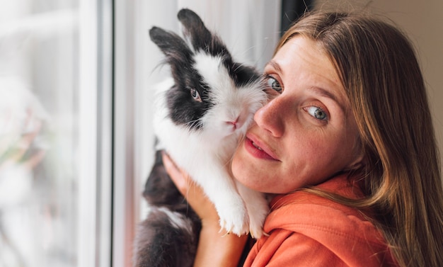 Foto grátis mulher acariciando coelho adorável