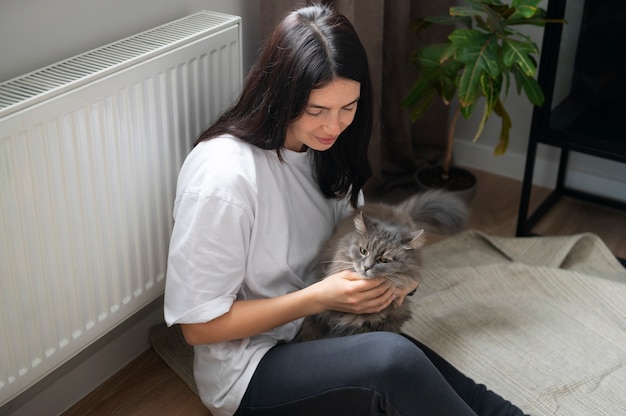 Mulher acariciando seu gato em casa durante a quarentena