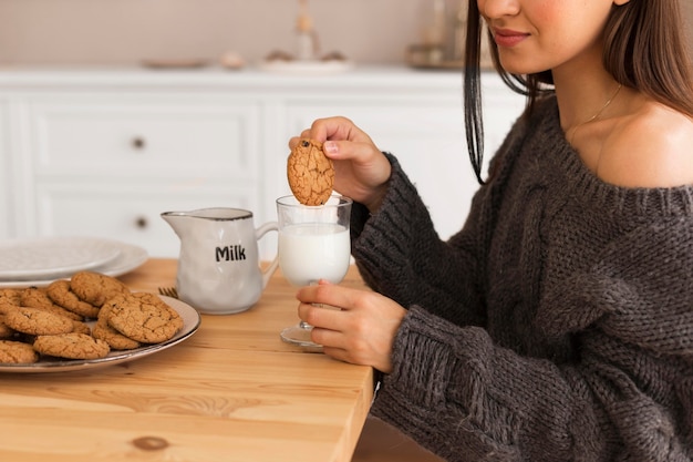 Foto grátis mulher aconchegante com biscoitos e leite