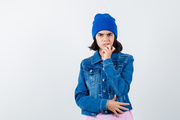 Mulher adolescente apoiando o queixo na mão fazendo uma careta em uma camiseta rosa e parecendo ansiosa