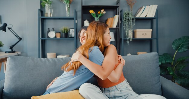 Mulher adolescente asiática feliz visita amigas íntimas abraçando e sorrindo em casa