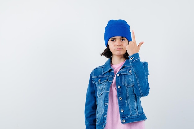 Mulher adolescente de camisa xadrez e gorro gesticulando isolada