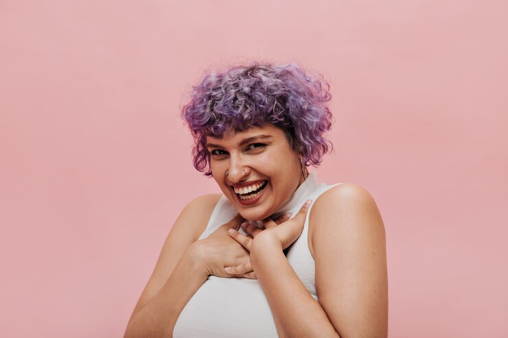 Foto grátis mulher adorável e encantadora com cabelo lilás brilhante parece fofa. mulher de cabelo curto sorridente posando.