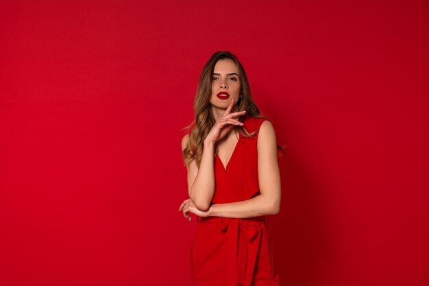 Mulher adorável elegante em vestido vermelho posando
