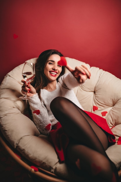 Mulher adorável rindo com copo de vinho se divertindo