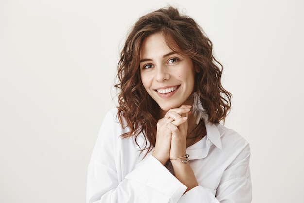 Mulher adorável sorrindo e parecendo emocionada ou grata