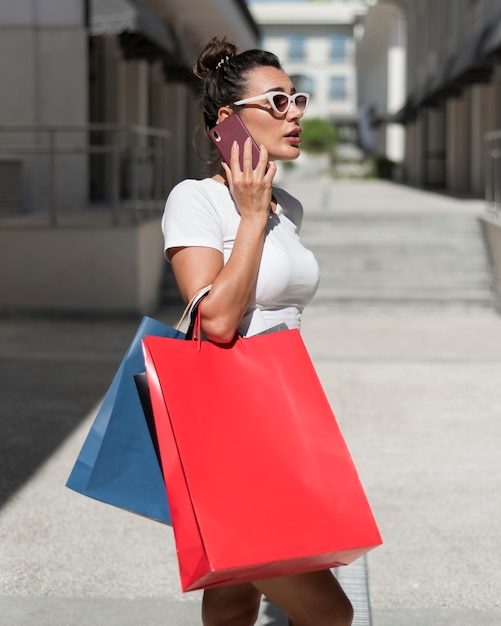 Foto grátis mulher adulta posando com sacolas de compras