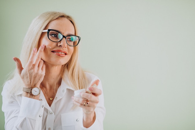 Mulher adulta usando creme anti-envelhecimento