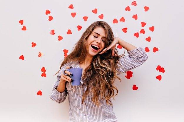 Mulher afável com cabelo castanho escuro sorrindo pela manhã