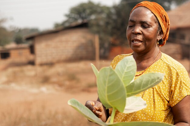 Mulher africana de tiro médio segurando a planta