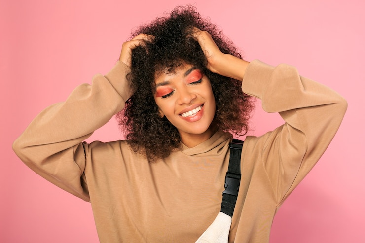 Foto grátis mulher africana feliz com maquiagem brilhante posando em rosa
