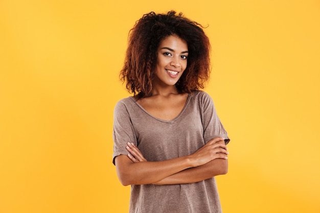 Mulher africana sorridente posando com braços cruzados