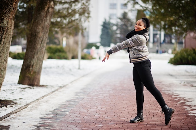 Mulher africana usa lenço preto caminha no caminho no dia de inverno na europa