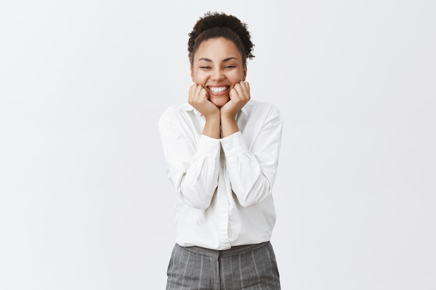 Mulher afro-americana alegre e fofa, trabalhadora de escritório parecendo encantada, sorrindo divertida