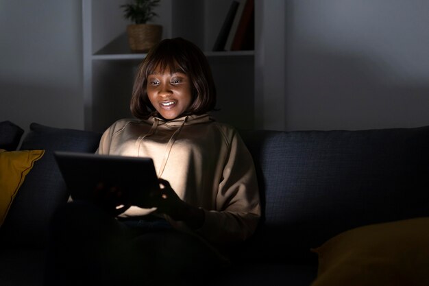 Mulher afro-americana assistindo serviço de streaming em casa