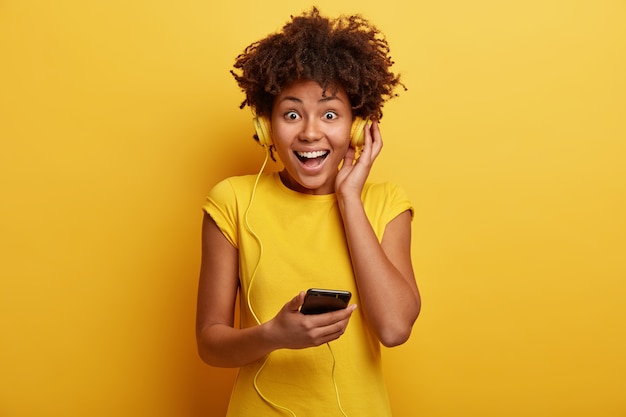 Mulher afro-americana com camiseta amarela e fones de ouvido