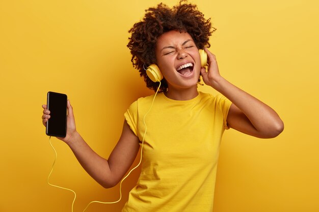 Mulher afro-americana com camiseta amarela e fones de ouvido