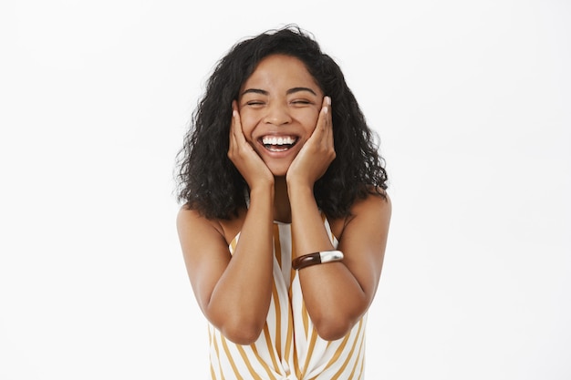 Foto grátis mulher afro-americana feliz, alegre e de aparência amigável, sentindo-se encantada e renovada