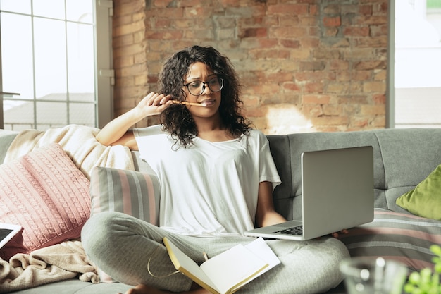 Mulher afro-americana freelancer durante o trabalho em um escritório doméstico durante a quarentena