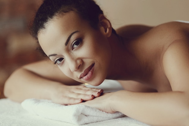 Mulher afro-americana, recebendo uma massagem relaxante no spa