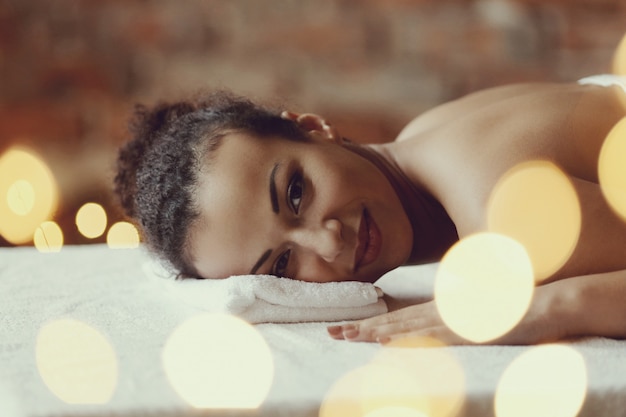 Mulher afro-americana, recebendo uma massagem relaxante no spa