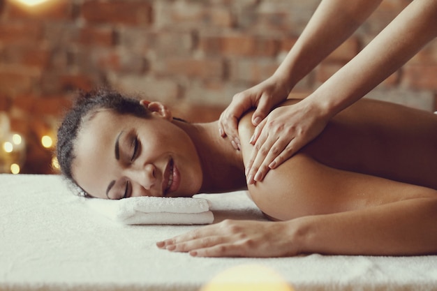 Mulher afro-americana, recebendo uma massagem relaxante no spa