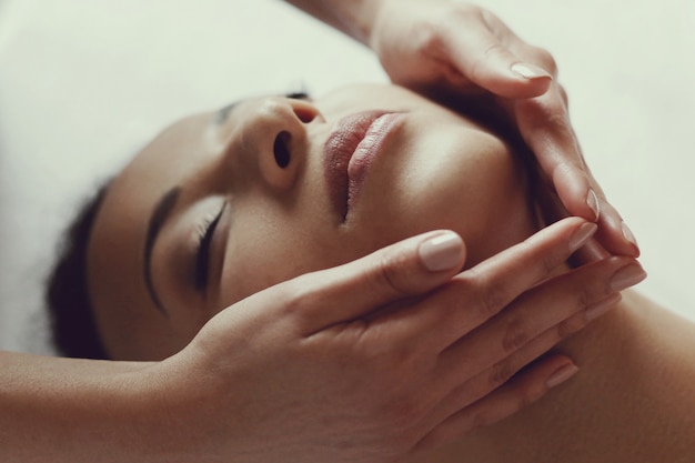 Mulher afro-americana, recebendo uma massagem relaxante no spa