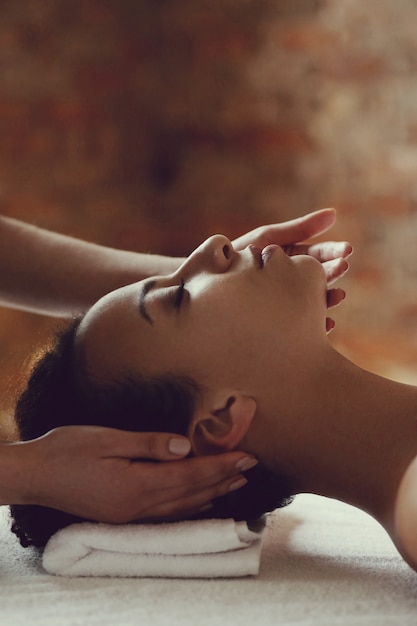Foto grátis mulher afro-americana, recebendo uma massagem relaxante no spa