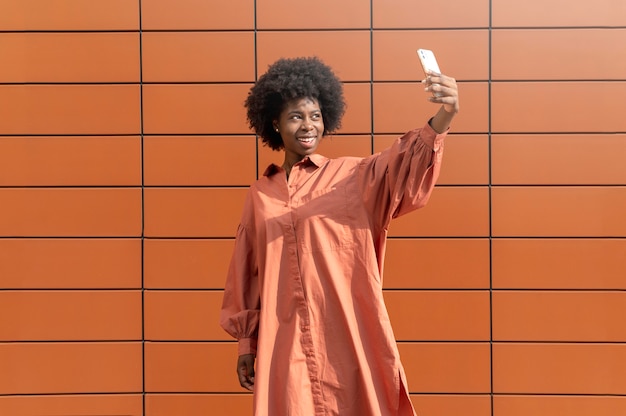 Mulher afro-americana tirando uma selfie com o smartphone
