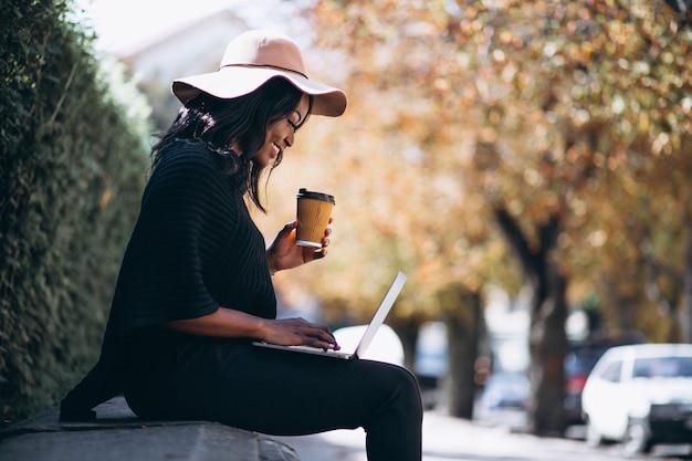 Mulher afro-americana, trabalhando em um computador ao ar livre