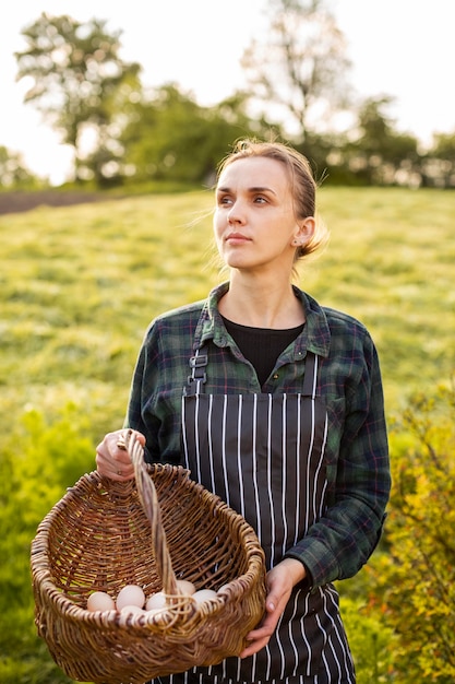 Mulher agricultora coletando ovos