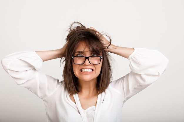 Mulher alarmada e angustiada, com problemas, desarruma o cabelo