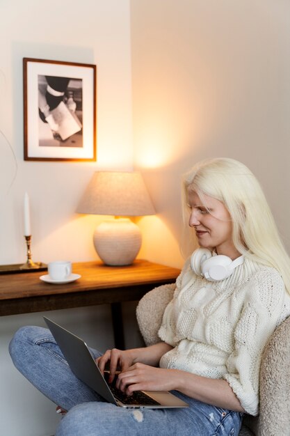 Mulher albina de vista lateral trabalhando no laptop