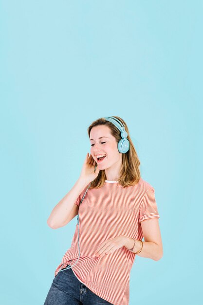 Mulher alegre ouvindo música em fones de ouvido