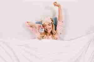 Foto grátis mulher alegre se espreguiçando na cama