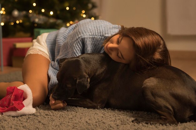 Mulher amando o cachorro dela no natal