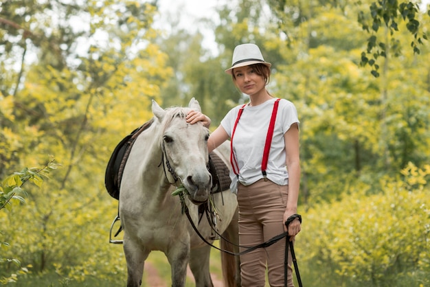 Mulher andando com um cavalo na zona rural