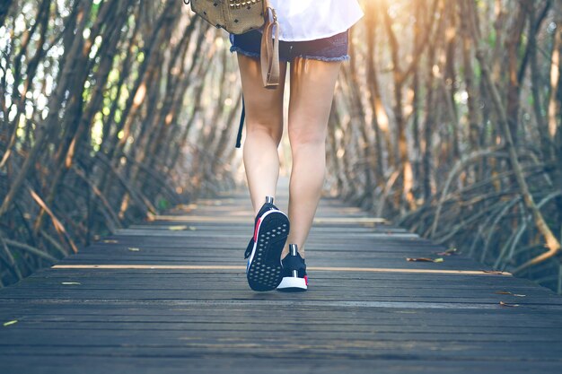 Mulher andando na ponte de madeira. Tom vintage.