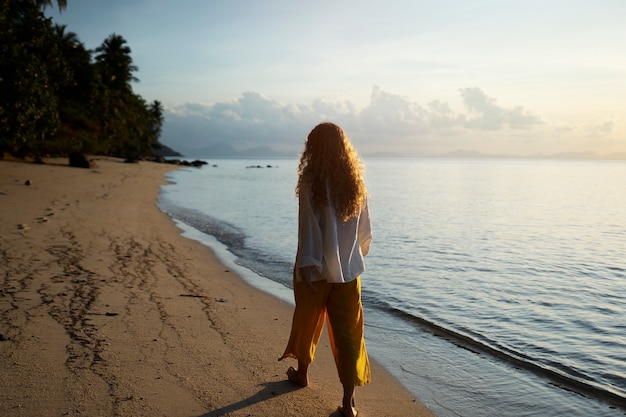 Foto grátis mulher andando na praia tiro completo