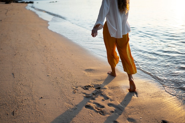 Foto grátis mulher andando na praia vista traseira
